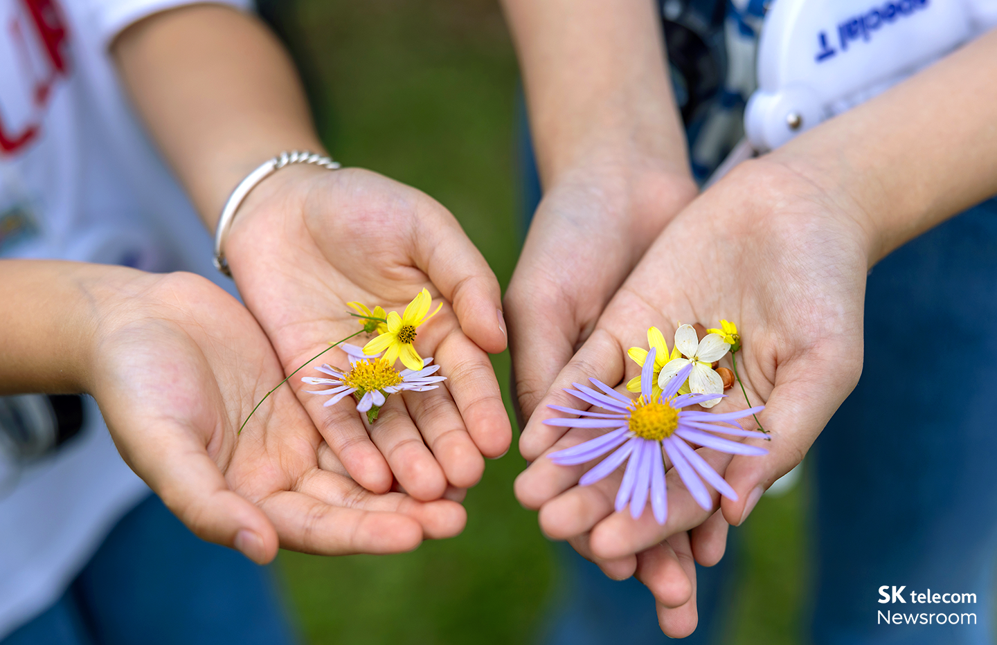 어린이 손 위에 꽃들이 올려져 있다